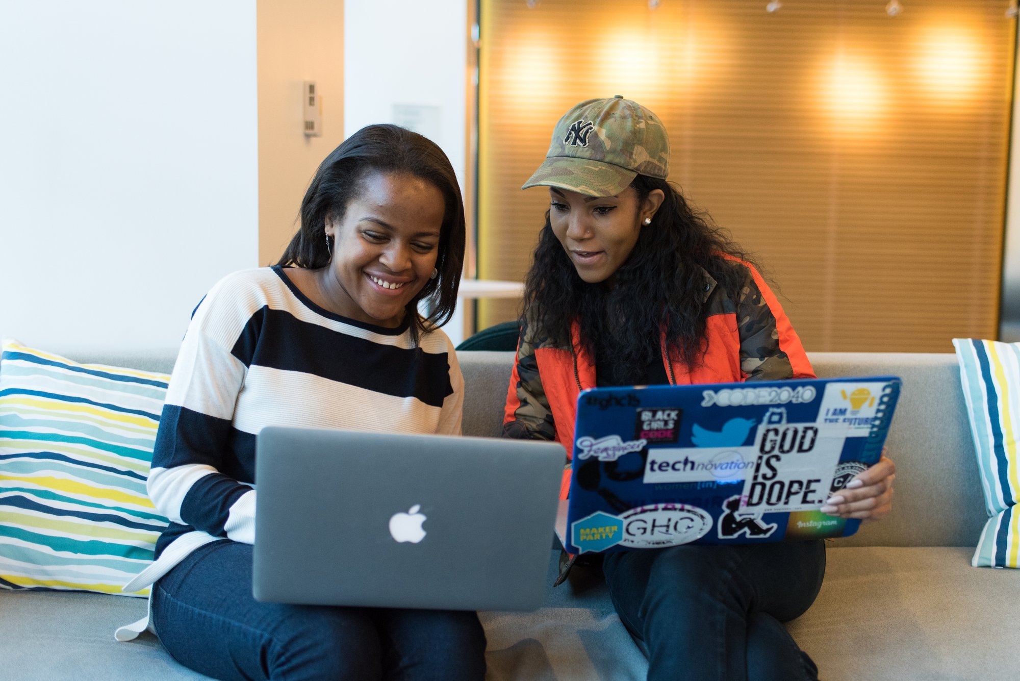 Canva - Two Women Holding Laptop