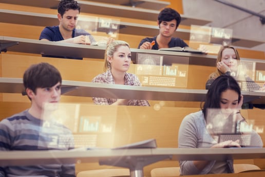 Concentrated students in lecture hall working on their futuristic tablet during lesson