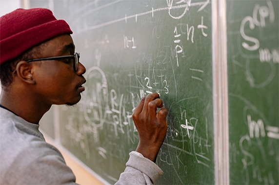 Student writing on chalkboard